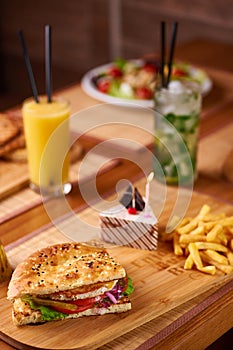 Fast food served table for company of friends. burger, french fries at birthday served table