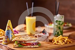 Fast food served table for company of friends. burger, french fries at birthday served table