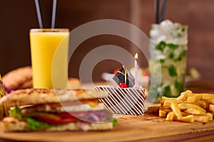 Fast food served table for company of friends. burger, french fries at birthday served table