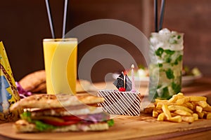 Fast food served table for company of friends. burger, french fries at birthday served table