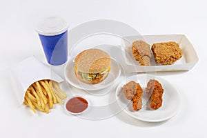 Fast food set containing burgers, fried chicken, french fries and soft drink isolated on white background