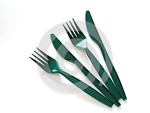 Fast food utensils with green plastic set of forks and knives isolated on white background