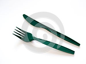 Fast food utensils with green plastic set of forks and knives isolated on white background