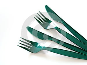 Fast food utensils with green plastic set of forks and knives isolated on white background