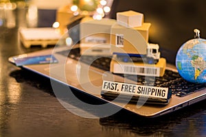 Fast, free shipping - still life logistics business concept with laptop, phone, mini shipping cartons