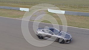 Fast grey car on racetrack drone footage