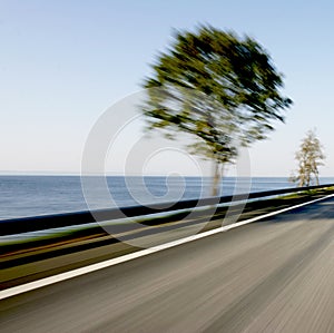 Fast motion blur on coastline road