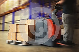 Fast Motion of Workers Unloading Package Boxes on Pallets in Storage Warehouse. Electric Forklift Pallet Jack Loader