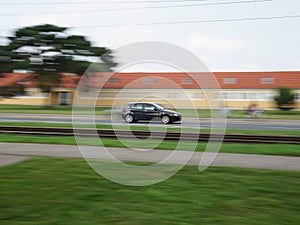 Fast moving black car with motion blur background