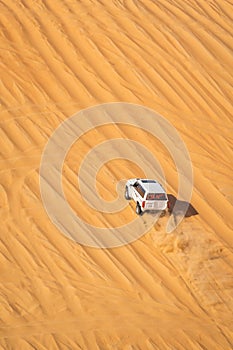 A fast moving car through desert during LIWA motor fest, moreeb dunes