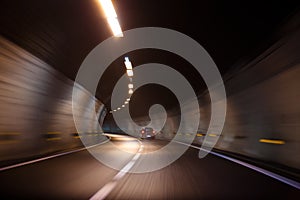 Fast moving car driving in a tunnel with lights and with very good quality of road inside it