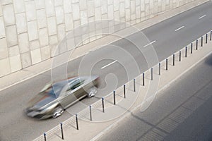 A fast moving car enters the tunnel.