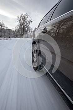 Fast moving car on a winter snowy road