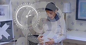 Fast moving clock and bokeh lights over happy a pregnant asian woman rubbing belly