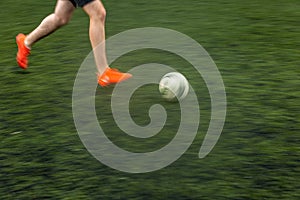 Fast moving feet of a soccer player on a pitch during a match