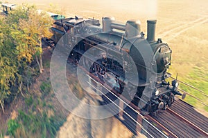 Fast moving steam train while driving between fields