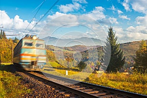 Fast moving train in autumn mountains