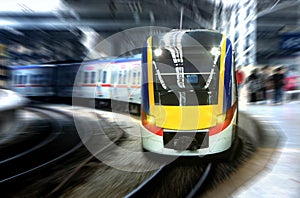 Fast moving train leaving station platform with motion blur