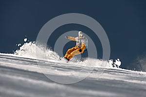 Fast snowboarder rides at ski slope