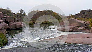 A fast stream among smooth dark and wet stones