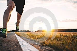 Fast strong runner feet running on asphalt road close up in sport shoe. Athlet run outdoor