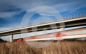Fast train passing under a bridge on a lovely summer day