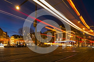 Fast tram running through The Hague, Den Haag in Dutch, city skyline at late evening