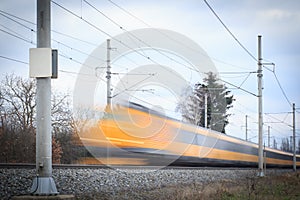 Fast yellow train on the railway motion blurred image