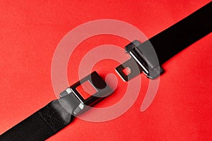 Fastened seat belt on red background with copy space, close-up