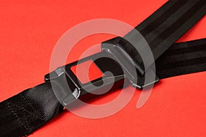 Fastened seat belt on red background with copy space, close-up