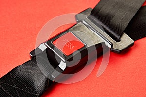 Fastened seat belt on red background with copy space, close-up