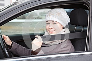 Fastened young woman sitting in car photo