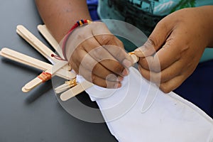 Fastening by device is part of the process of making tie-dye fabrics.