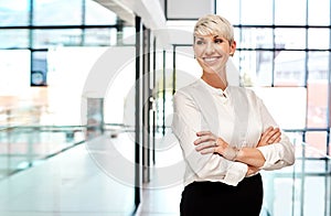 The fastest way to build your business is to build your confidence. a young businesswoman standing with her arms crossed