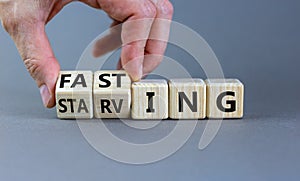 Fasting or starving symbol. Doctor turns wooden cubes and changes the word `starving` to `fasting`. Beautiful grey background,