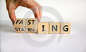 Fasting or starving symbol. Doctor turns wooden cubes and changes the word `starving` to `fasting`. Beautiful white background