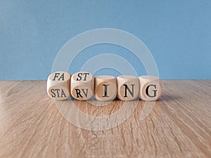 Fasting or starving symbol.Turned wooden cubes and changes the word \'starving\' to \'fasting\'