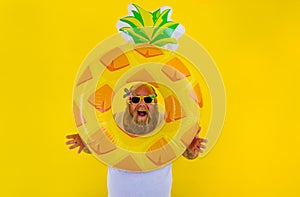 Fat amazed man with wig in head is ready to swim with a donut lifesaver