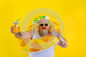 Fat amazed man with wig in head is ready to swim with a donut lifesaver