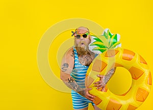 Fat amazed man with wig in head is ready to swim with a donut lifesaver