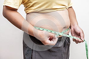 Fat asia girl with overweight checking out his weight, hand holding measurement tape on her belly fat.woman diet lifestyle and