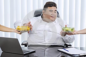 Fat Asian businessman preferring salad over chips
