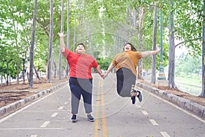 Fat Asian couple jumping happily and joyfully