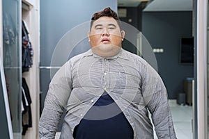 Fat Asian man wearing tight unbuttoned shirt