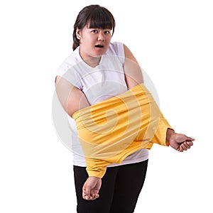 Fat asian woman trying to wear small size of yellow t-shirt isolated on white. Fat and Healthcare concept