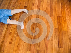 Fat Boy Lying on The Wooden Parquet Floor