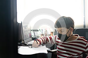 A fat boy is studying online with a tablet and a book at his mother`s office