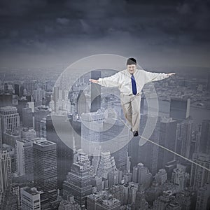 Fat businessman walking on the rope