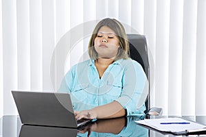 Fat businesswoman working at her laptop seriously