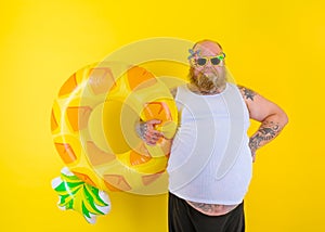 Fat delusion man with wig in head is ready to swim with a donut lifesaver
